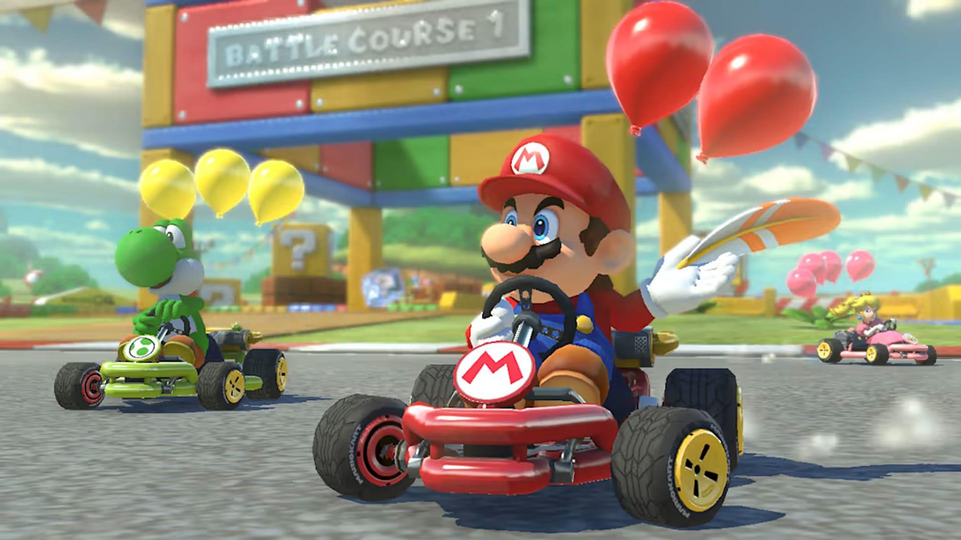 Mario and Yoshi in karts with balloons, Peach racing in background, outdoor track area.
